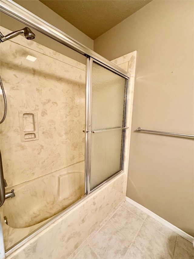 full bath with baseboards, shower / bath combination with glass door, and tile patterned floors