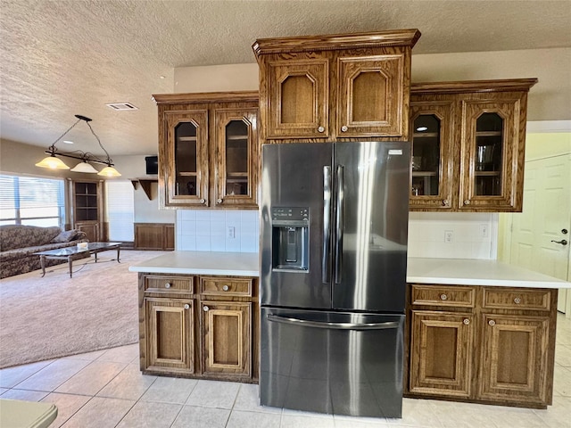 kitchen featuring open floor plan, light countertops, stainless steel refrigerator with ice dispenser, and visible vents