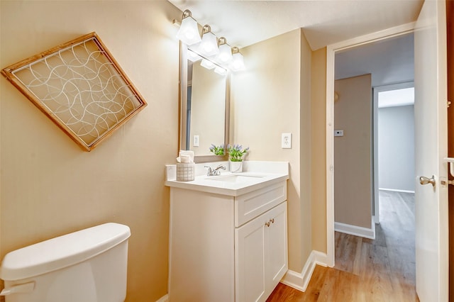 bathroom featuring vanity, toilet, and hardwood / wood-style floors