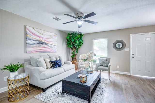 living room with wood-type flooring and ceiling fan