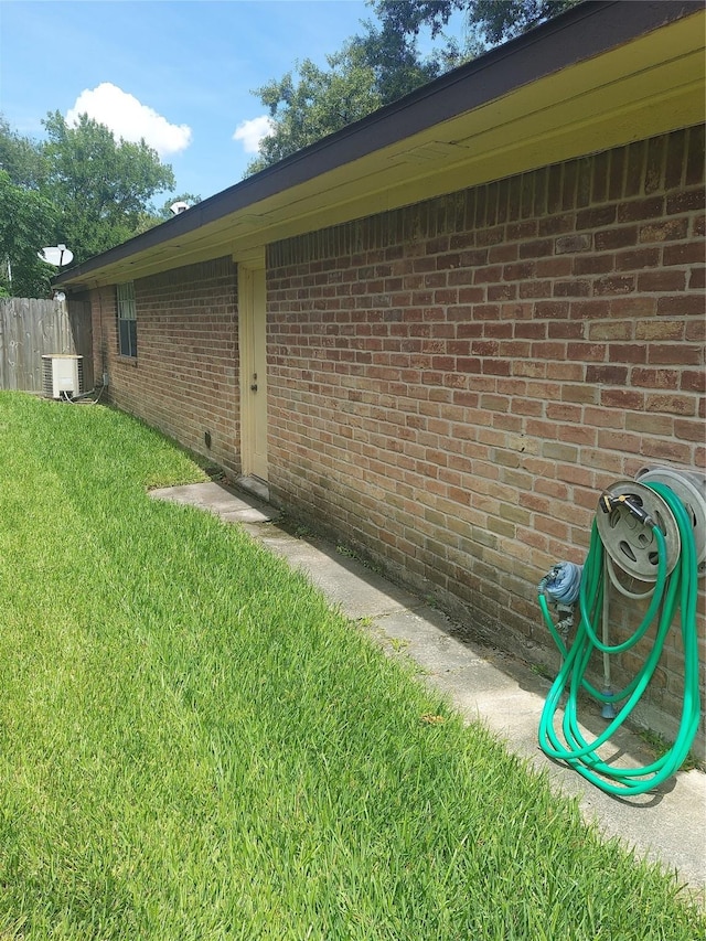 view of side of home with a yard and central air condition unit