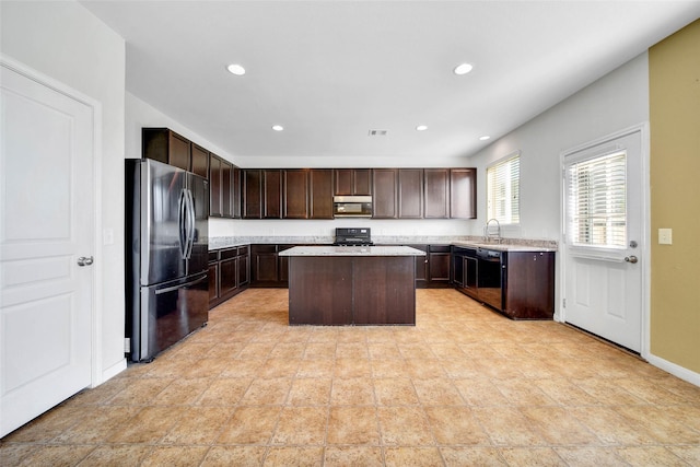 kitchen featuring a center island, freestanding refrigerator, black dishwasher, and light countertops