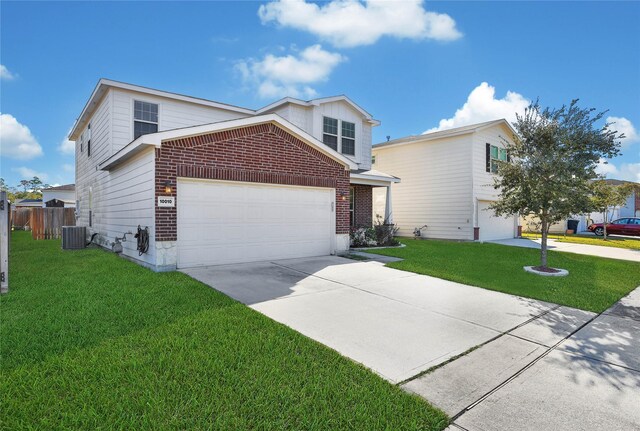 view of front of home featuring a garage, a front yard, and central AC unit