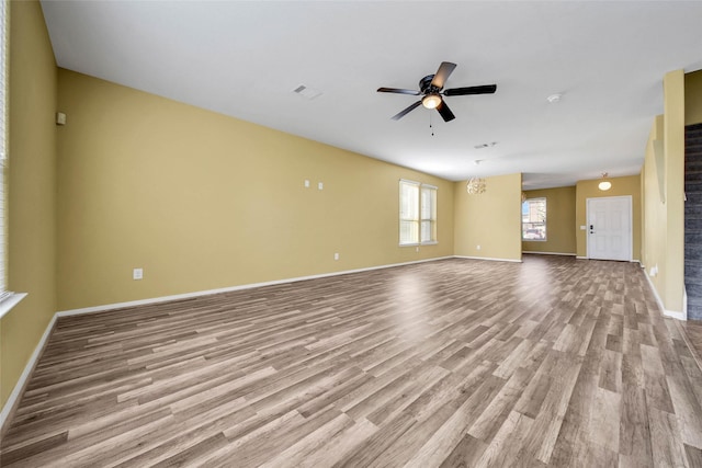 unfurnished living room with baseboards, light wood-style flooring, visible vents, and a ceiling fan