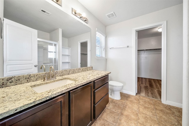 full bathroom with baseboards, visible vents, a spacious closet, and vanity