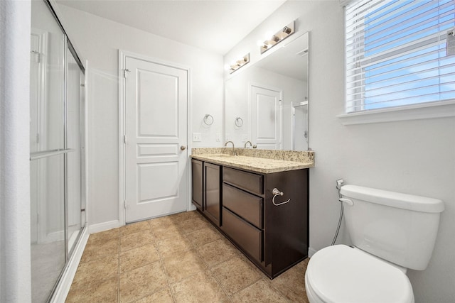 bathroom featuring vanity, toilet, and a shower with door