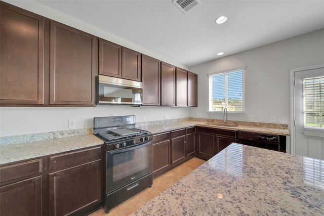 kitchen featuring dark brown cabinetry, light stone countertops, sink, and black appliances