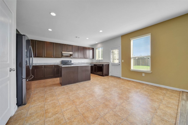 kitchen featuring dark brown cabinetry, sink, a center island, and appliances with stainless steel finishes