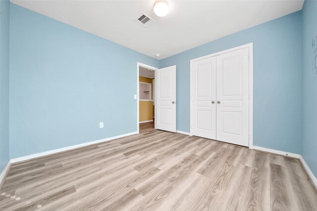 unfurnished bedroom featuring a closet and light hardwood / wood-style flooring