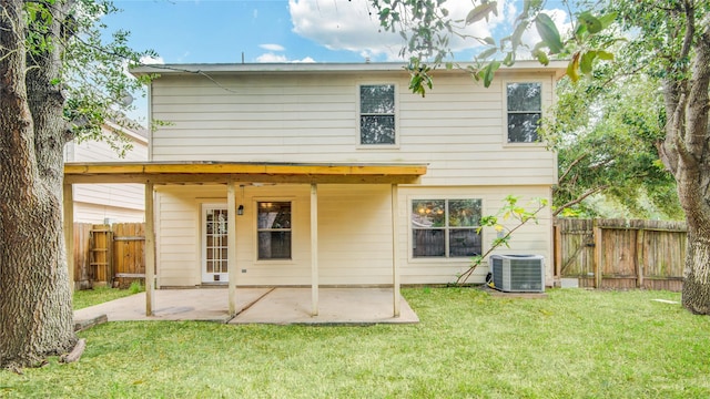 back of house featuring cooling unit, a lawn, and a patio