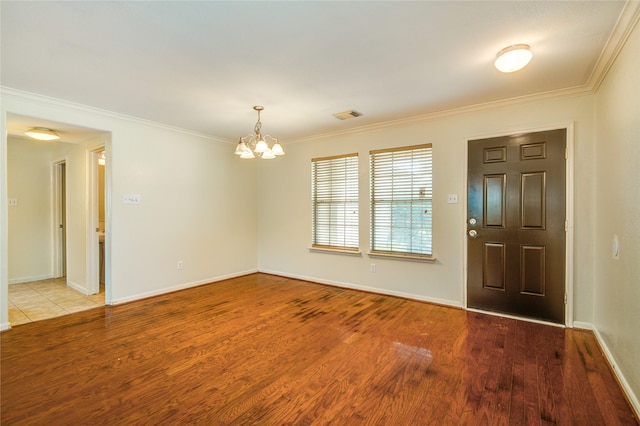 entrance foyer with ornamental molding, a chandelier, and light hardwood / wood-style flooring