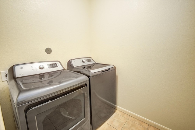 laundry area featuring washer and dryer and light tile patterned floors