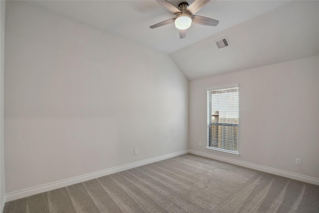 empty room with vaulted ceiling, light colored carpet, and ceiling fan