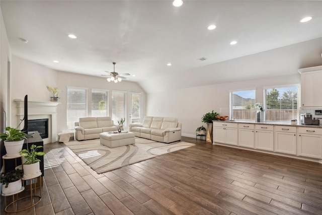 living room featuring dark hardwood / wood-style flooring, lofted ceiling, and ceiling fan