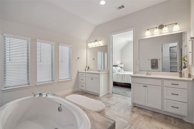 bathroom with vanity and lofted ceiling