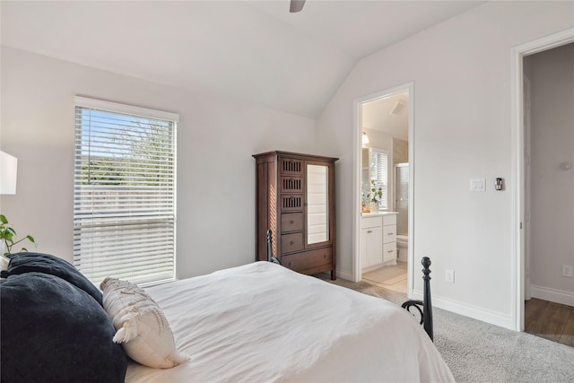 carpeted bedroom featuring vaulted ceiling, ceiling fan, and ensuite bath