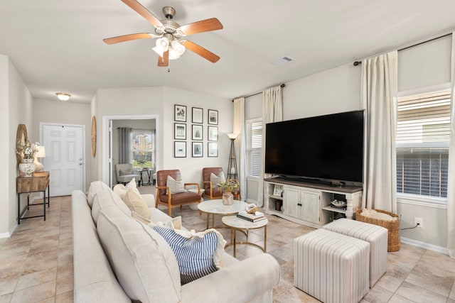 tiled living room featuring ceiling fan and plenty of natural light