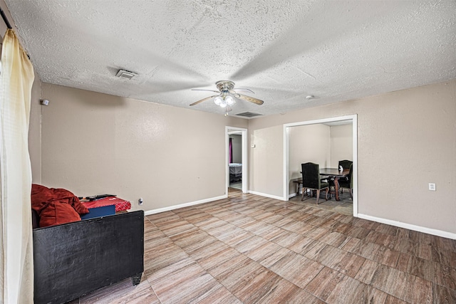 sitting room featuring ceiling fan and a textured ceiling