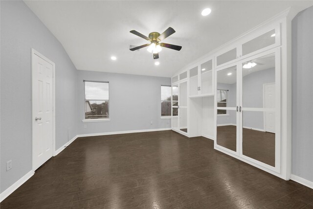 empty room featuring lofted ceiling, dark wood-type flooring, and ceiling fan