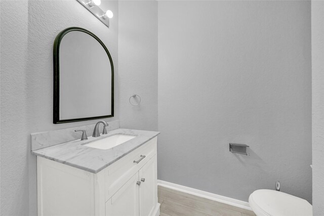 bathroom with vanity, hardwood / wood-style floors, and toilet