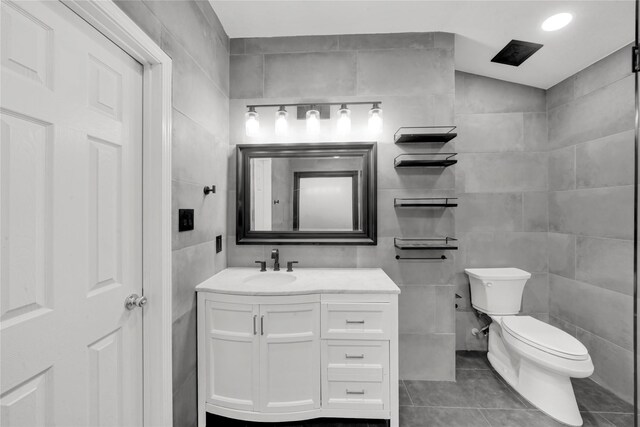 bathroom featuring tile walls, vanity, tile patterned floors, and toilet