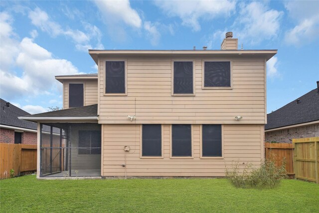 back of house featuring a yard and a sunroom