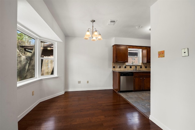 unfurnished dining area featuring an inviting chandelier and dark hardwood / wood-style flooring