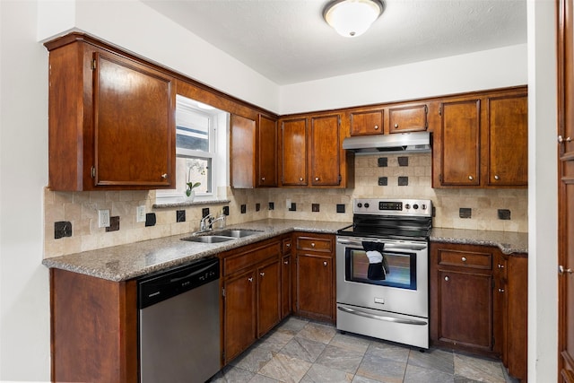 kitchen with sink, decorative backsplash, dark stone counters, and appliances with stainless steel finishes