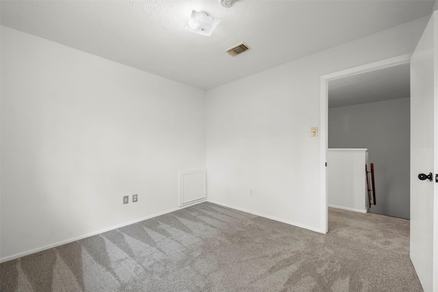 unfurnished room featuring carpet and a textured ceiling