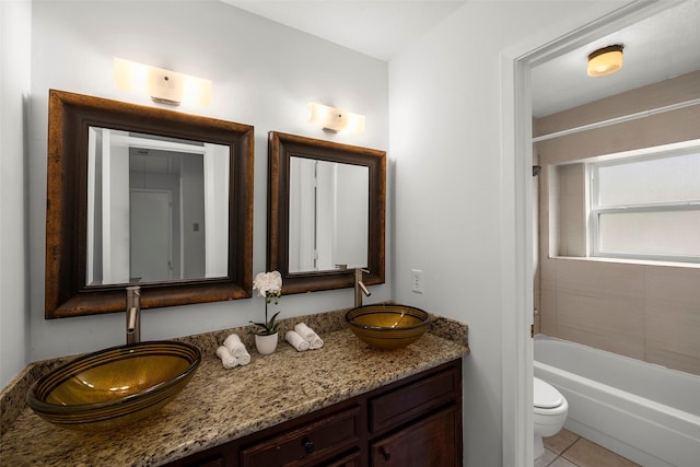 full bathroom featuring vanity, tiled shower / bath combo, tile patterned floors, and toilet