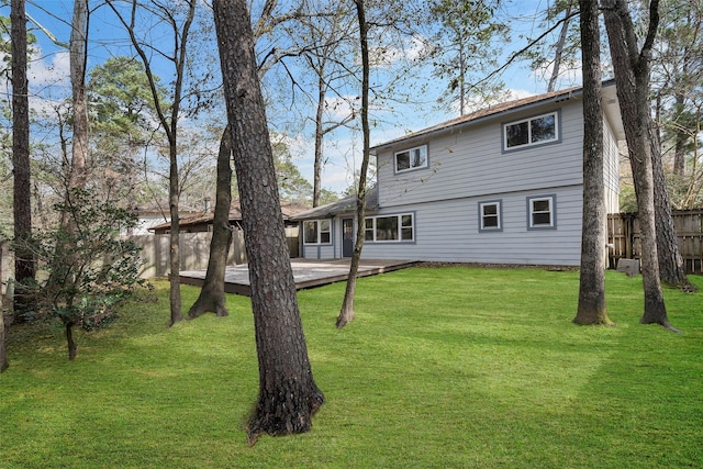 back of property with a wooden deck and a lawn