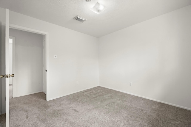 unfurnished room featuring carpet and a textured ceiling