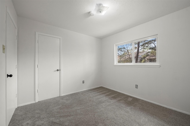 empty room with a textured ceiling and carpet