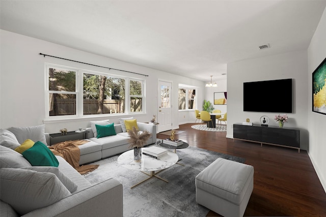 living room with dark hardwood / wood-style floors and a chandelier