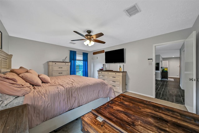 bedroom featuring ceiling fan, dark hardwood / wood-style flooring, and a textured ceiling