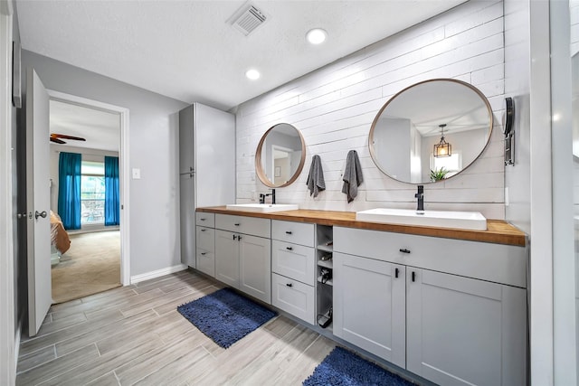 bathroom with tasteful backsplash, vanity, hardwood / wood-style floors, and a textured ceiling