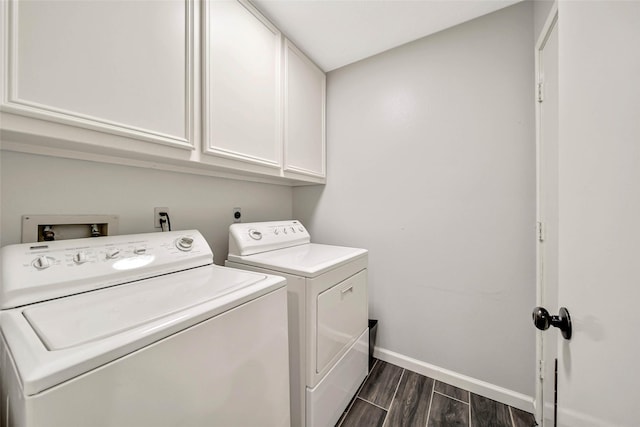 washroom featuring cabinets, dark hardwood / wood-style flooring, and washer and clothes dryer