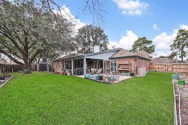 back of house with a storage unit, a patio, and a lawn