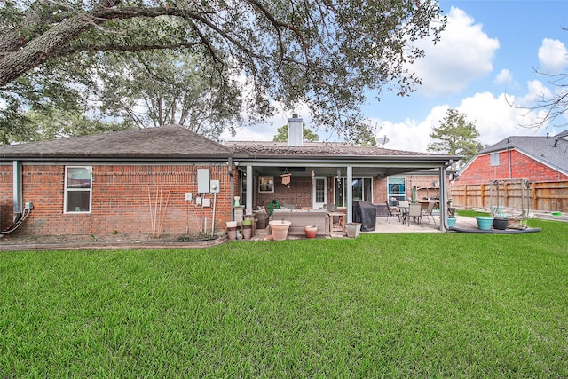 back of property with a lawn and a patio area