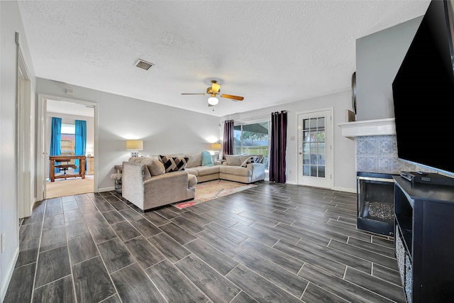 living room featuring a textured ceiling and ceiling fan