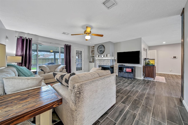 living room featuring ceiling fan and a textured ceiling