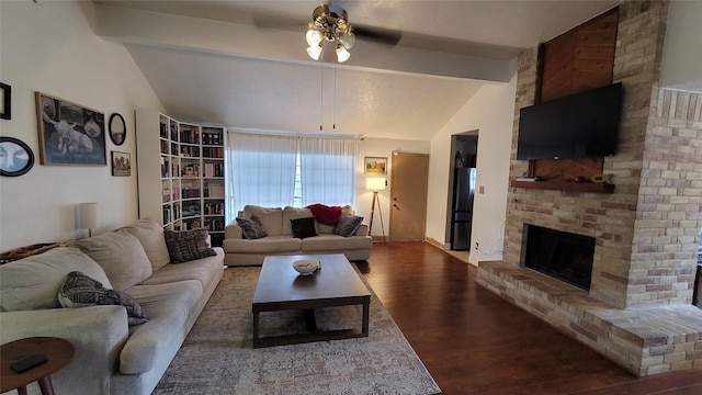 living room with a brick fireplace, lofted ceiling with beams, hardwood / wood-style floors, and ceiling fan