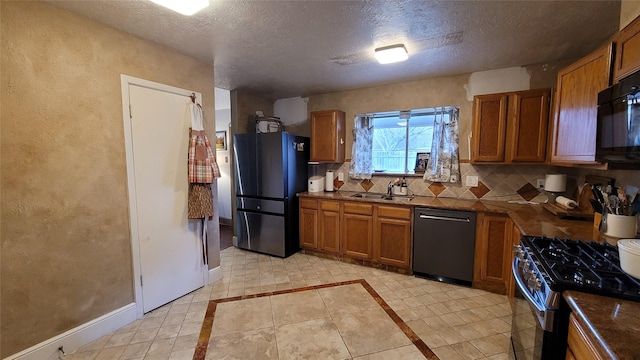 kitchen with stainless steel appliances, sink, a textured ceiling, and backsplash