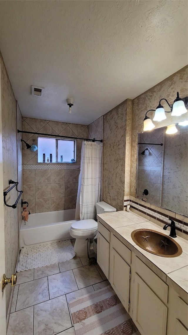 full bathroom featuring shower / bath combo, vanity, a textured ceiling, and toilet