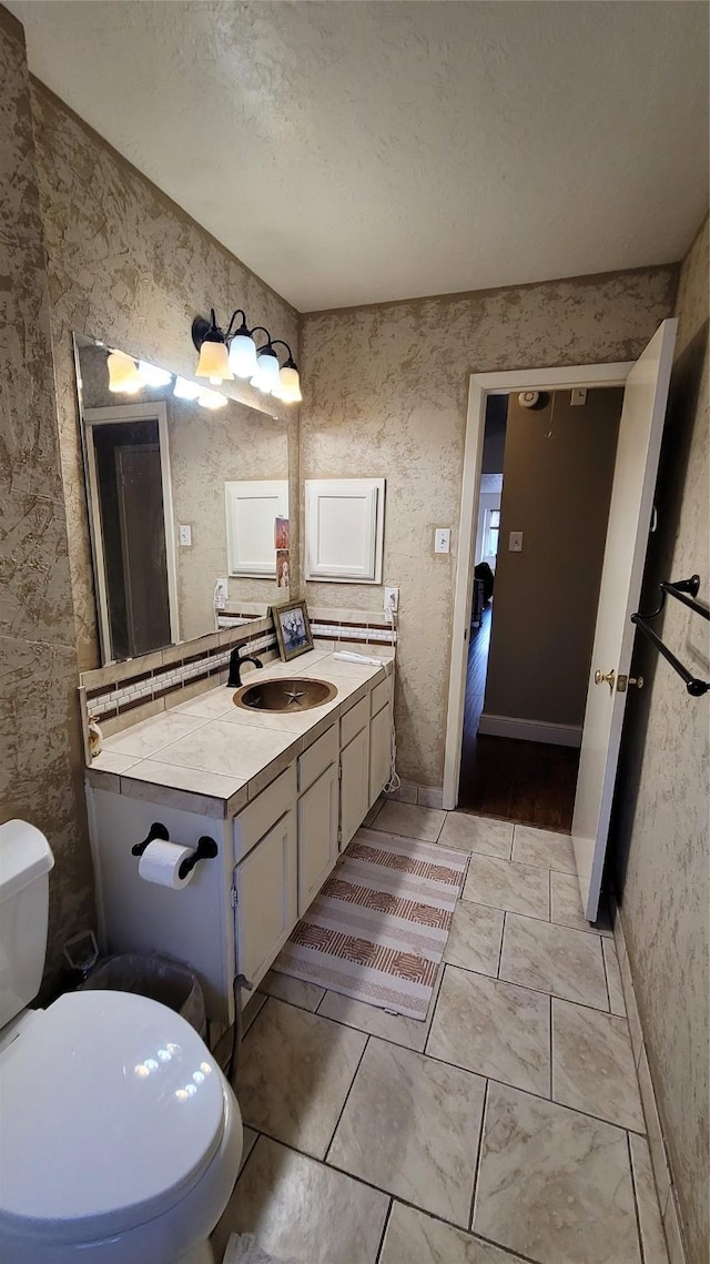 bathroom with vanity, a textured ceiling, and toilet