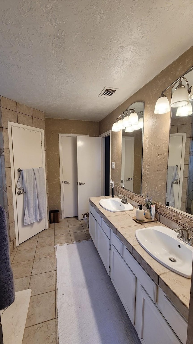 bathroom with vanity, tile patterned flooring, and a textured ceiling