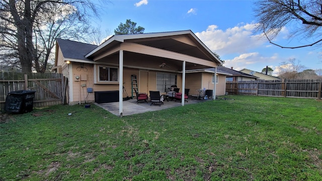 back of house featuring a patio area and a lawn