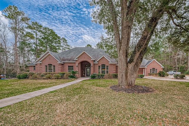 view of front of house featuring a front yard and brick siding