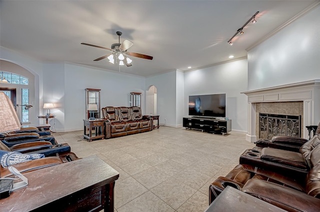 living area featuring ornamental molding, arched walkways, and baseboards