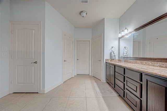 bathroom featuring tile patterned flooring, baseboards, a closet, and vanity